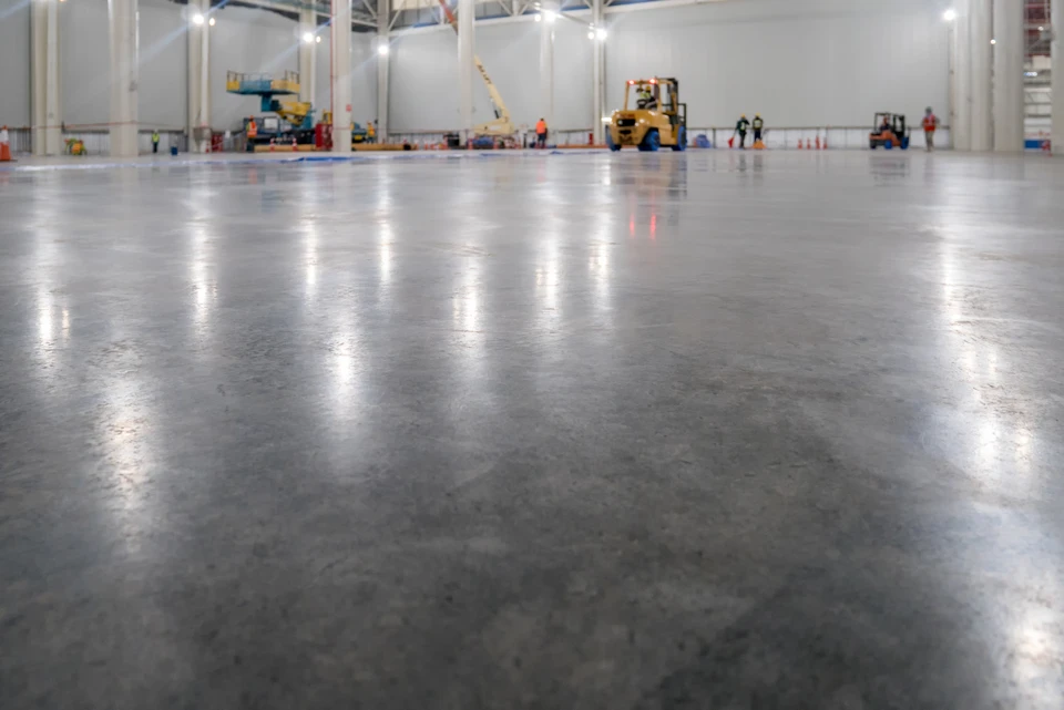 Surface de béton texturée avec rainures parallèles créées par brossage ou balayage